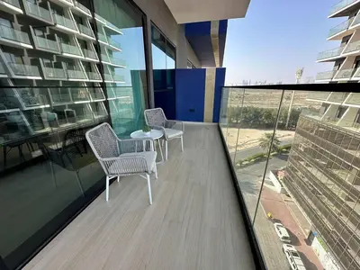 a balcony with two chairs and a table on a building at Stylish 1br Jvc Spacious Layout Pool View in Dubai