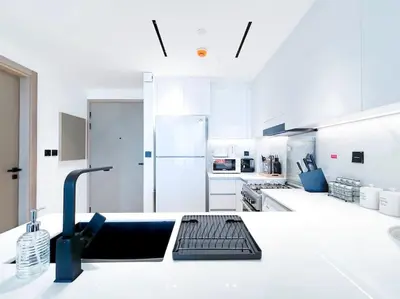 a kitchen with white counters and a sink in it at City Views & Comforts at Binghatti Corner in Dubai