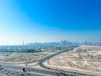 an aerial view of a highway with a city in the background at City Views & Comforts at Binghatti Corner in Dubai
