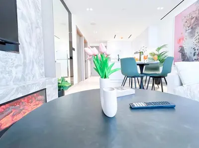 a living room with a table with a vase with flowers at City Views & Comforts at Binghatti Corner in Dubai