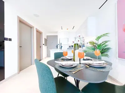 a dining room with a table and blue chairs at City Views & Comforts at Binghatti Corner in Dubai