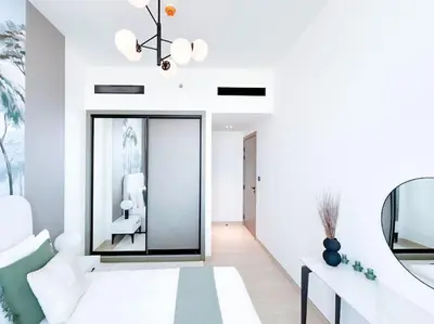 a living room with white walls and a mirror at City Views & Comforts at Binghatti Corner in Dubai