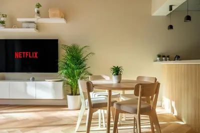 a dining room with a table and chairs and a tv at Boho Nordic Bliss in Dubai in Dubai