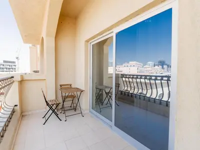 a balcony with chairs and a table and a view at Serene 1BR in Diamond Views 3 JVC - Pool Access & Peaceful Living , Managed by Think Realty in Dubai