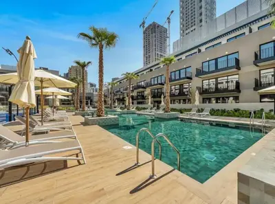 a swimming pool with chaise lounge chairs next to a building at Luxury Studio apartment in JVC, Oakley Square Residences in Dubai