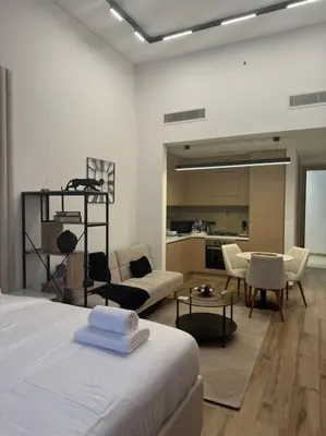 a room with a bed and a living room at Luxury Studio apartment in JVC, Oakley Square Residences in Dubai