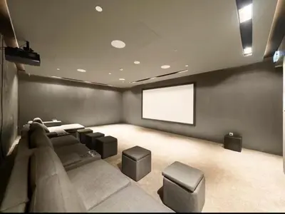 a theater room with a couch and a screen at Luxury Studio apartment in JVC, Oakley Square Residences in Dubai