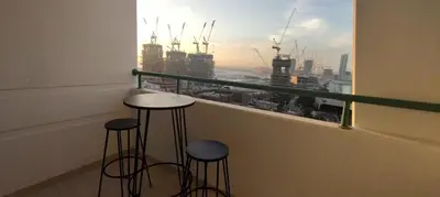 a balcony with two stools and a view of a city at Marina Crown 1 BR Modern Apartment Full Sea View in Dubai