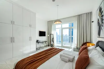 a bedroom with a large bed with a large window at ShoresInn - Aesthetic Stay with Dubai Marina View in Dubai
