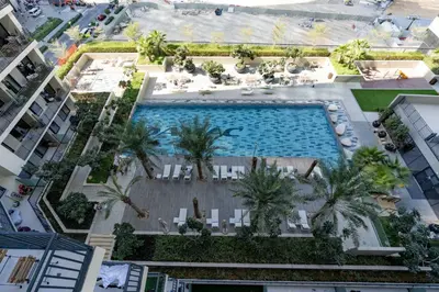 an overhead view of a pool with palm trees and buildings at Stylish and Versatile for Business or Leisure in Dubai