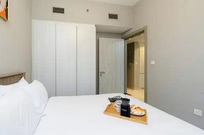 a white bed with a tray of food on it at Stylish and Versatile for Business or Leisure in Dubai