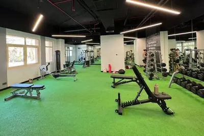 a gym with a green carpeted floor and tread machines at Sophisticated 3 Bed Palm Jumeirah w Beach Access in Dubai