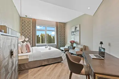 a hotel room with a bed and a desk and a window at Sophisticated 3 Bed Palm Jumeirah w Beach Access in Dubai