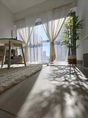 a living room with a large window and a table at Luxurious apartment in Downtown, Dubai in Dubai