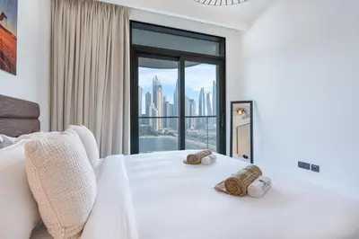 a bedroom with a white bed with a large window at Modern Home with Incredible View & Private Beach in Dubai