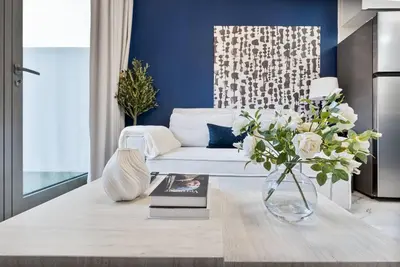 a living room with a white couch and a vase of flowers at Serene Studio APT with Pool and Gym in Dubai