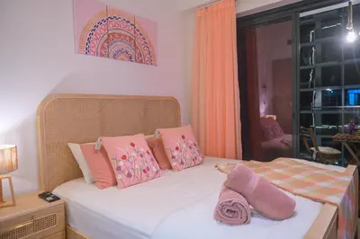 a bedroom with a bed with pink and pink pillows at UrbanHomes - Cozy, Wooden and Travel Eco-Friendly Studio in Dubai