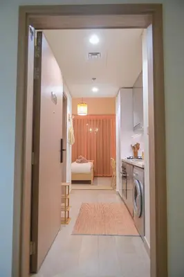 a hallway leading to a kitchen with a washer and dryer at UrbanHomes - Cozy, Wooden and Travel Eco-Friendly Studio in Dubai