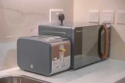 a toaster and a toaster oven sitting on a counter at UrbanHomes - Cozy, Wooden and Travel Eco-Friendly Studio in Dubai
