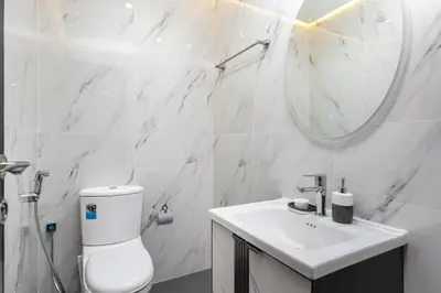a white bathroom with a toilet and a sink at Chic 2BR Apartment in Dubai Marina, near Marina Beach and The Walk in Dubai