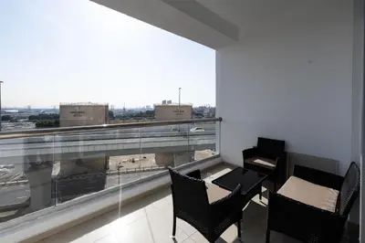 a balcony with chairs and a table and a large window at Chic 2BR Apartment in Dubai Marina, near Marina Beach and The Walk in Dubai