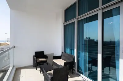 a balcony with chairs and tables on a building at Chic 2BR Apartment in Dubai Marina, near Marina Beach and The Walk in Dubai