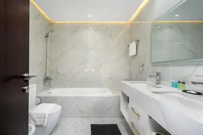 a bathroom with a tub and a toilet and a sink at Chic 2BR Apartment in Dubai Marina, near Marina Beach and The Walk in Dubai