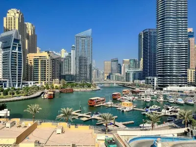 a river with boats in a city with tall buildings at Chic 2BR Apartment in Dubai Marina, near Marina Beach and The Walk in Dubai
