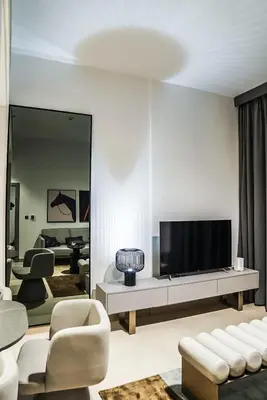 a living room with a flat screen tv on a wall at Stylish & Cozy Apartment Awaits You in Dubai