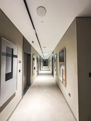 an empty hallway in a building with paintings on the walls at Stylish & Cozy Apartment Awaits You in Dubai