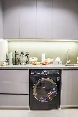 a washing machine in a kitchen with a counter at Stylish & Cozy Apartment Awaits You in Dubai