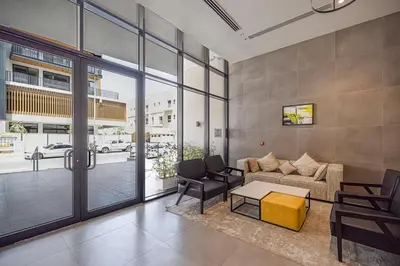a living room with a couch and a table at UrbanHomes - Cozy Spacious Exceptional Studio in Heart of Dubai at JVC in Dubai