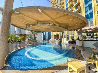 a large swimming pool under an umbrella on top of a building at Luxury Apartments - Stunning Marina View - 5-Star Hotel Amenities in Dubai