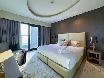 a bedroom with a large bed and a large window at Spacious & Cozy 1BR - Stunning City View in Dubai