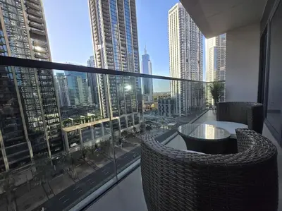 a room with a large window with a table and chairs at Chic 1BR Retreat , Blvd Views, Walk to Dubai Mall in Dubai