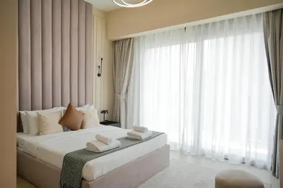 a bedroom with a bed with white towels on it at Chic 1BR Retreat , Blvd Views, Walk to Dubai Mall in Dubai
