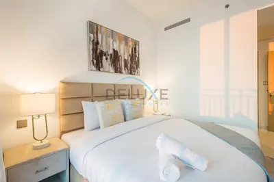 a bedroom with a large white bed and a lamp at Appealing 3BR at 17 Icon Bay Dubai Creek Harbour by Deluxe Holiday Homes in Dubai