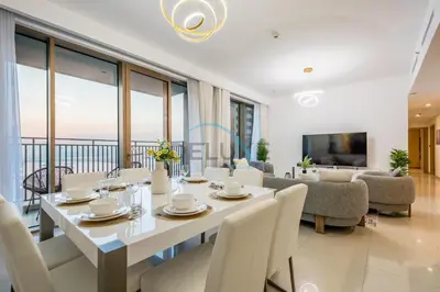 a dining room with a white table and chairs at Appealing 3BR at 17 Icon Bay Dubai Creek Harbour by Deluxe Holiday Homes in Dubai