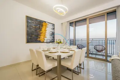 a dining room with a table and chairs and a balcony at Appealing 3BR at 17 Icon Bay Dubai Creek Harbour by Deluxe Holiday Homes in Dubai