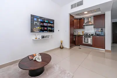 a living room with a table and a kitchen at Downtown Studio with Balcony at 29Blvd in Dubai