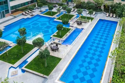an overhead view of a large pool with tables and chairs at Downtown Studio with Balcony at 29Blvd in Dubai