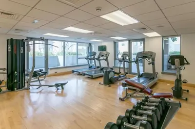 a gym with several treadmills and elliptical machines at Downtown Studio with Balcony at 29Blvd in Dubai