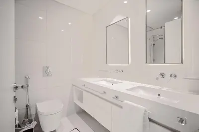 a white bathroom with a sink and a mirror at Emaar Beachfront Luxe Retreat in Dubai