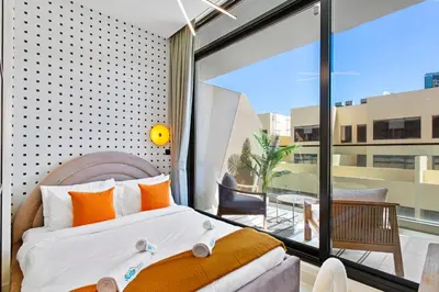 a bedroom with a king sized bed and a balcony at Sleek Brand New Studio in Loci Residence JVC in Dubai