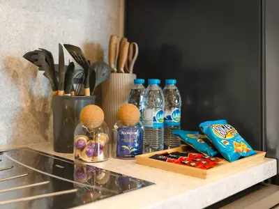 a counter top with bottles of water and spices at UrbanStays Dubai - Act Tower in Dubai