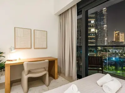 a bedroom with a desk and a bed and a window at UrbanStays Dubai - Act Tower in Dubai