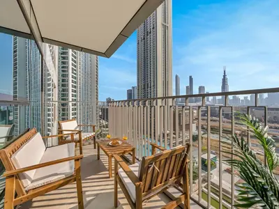 a balcony with chairs and a table and a view of the city at UrbanStays Dubai - Downtown Views II in Dubai