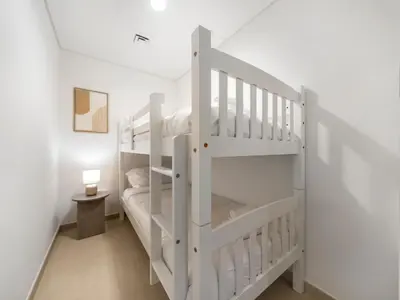a white bunk bed in a white room with a lamp at UrbanStays Dubai - Downtown Views II in Dubai