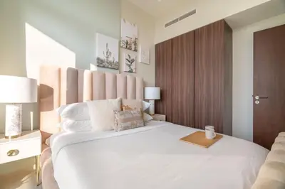 a bedroom with a large white bed with a wooden headboard at GuestReady - Charming home in Business Bay in Dubai
