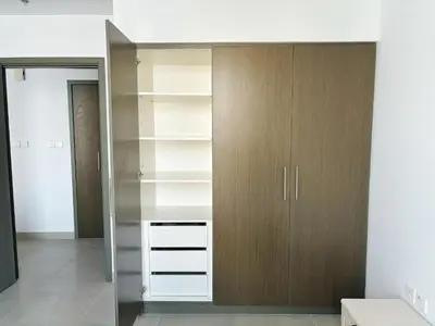 a walk in closet with wooden cabinets at 'Dubai Creek Horizon Tower2' 1-Bedroom in Dubai